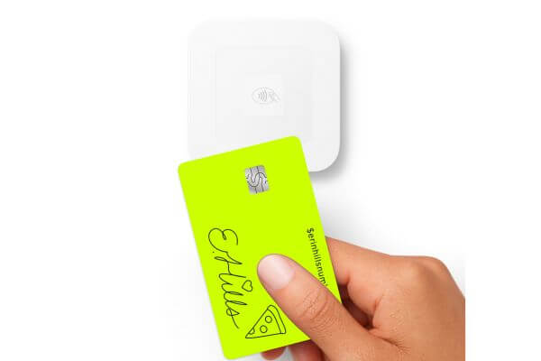Image of a  neon-colored card held by a man's hand.