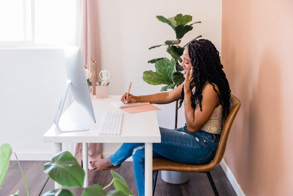 Woman working at desk. Looking for jobs where you work alone? If you're an introvert or simply want minimal human interaction, here are 40 work alone jobs.