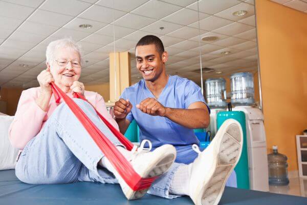 The picture of a therapist and patient working on some exercise.