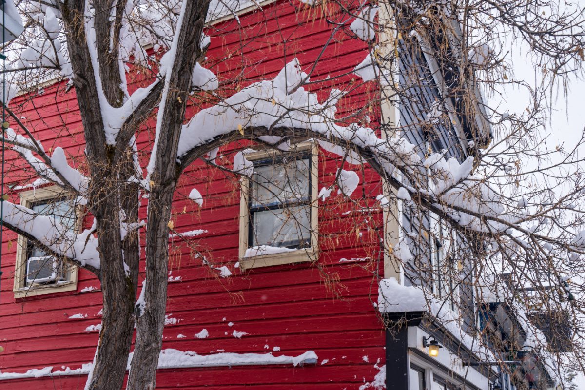 Snow on a colonial house in Lone Tree, CO, a suburb with small town charm that features the park meadows mall, boutique shops and upscale suburban homes.