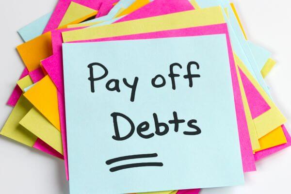 Image of a colored paper in yellow, blue, and pink with a signage of Pay off Debts.
