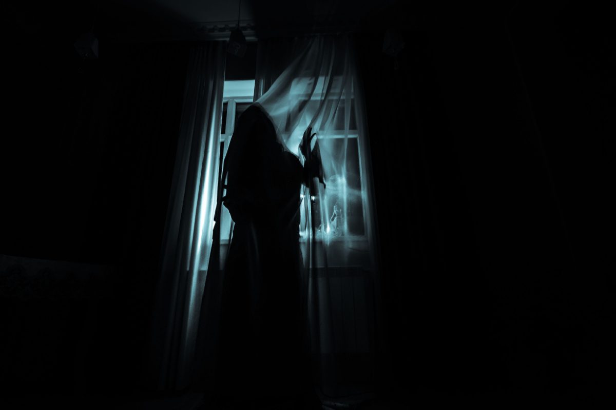 Female figure in the window of a haunted house